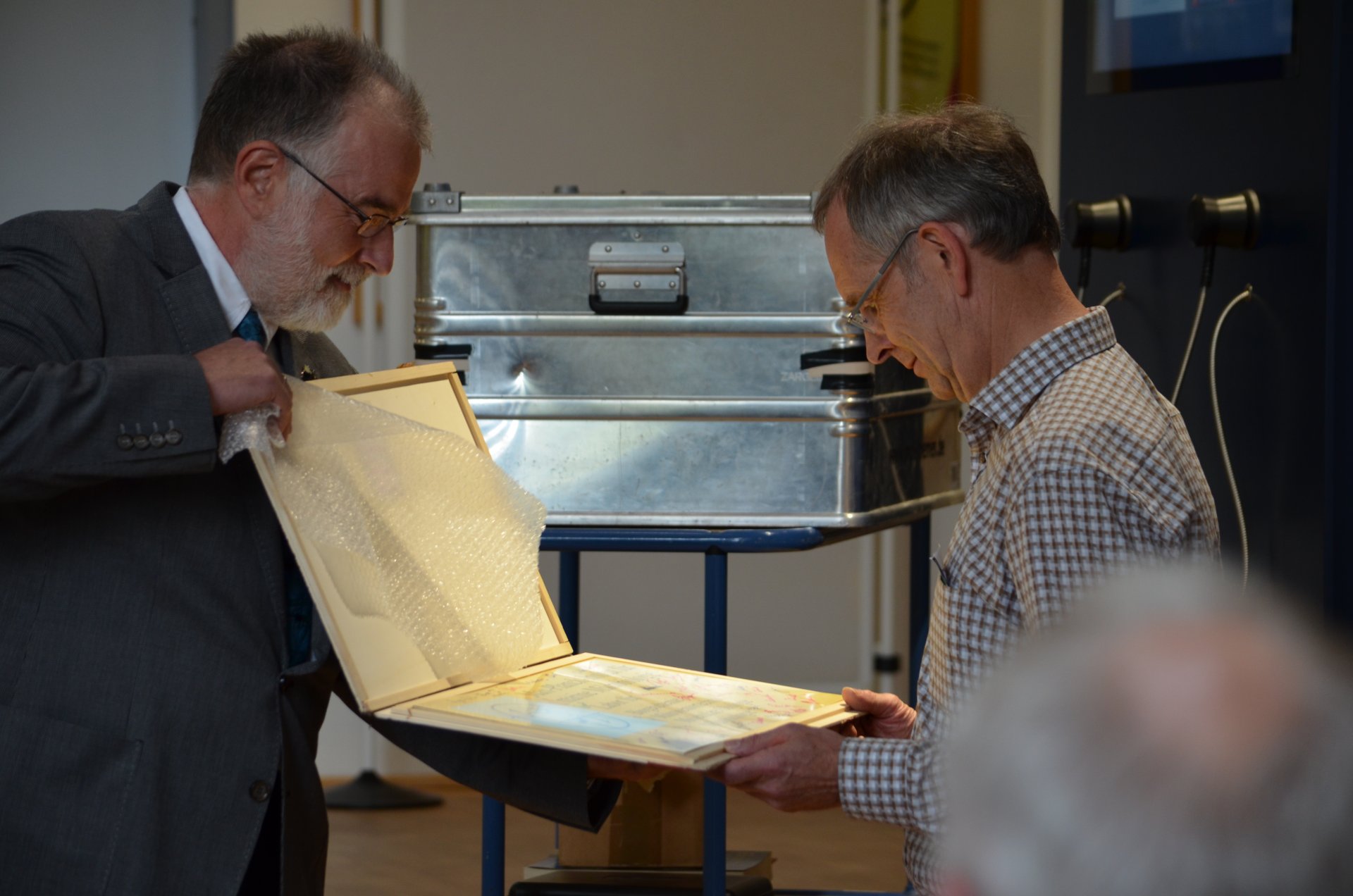 As a farewell present, Friedrich Widdel is presented the information sign that marked the entrance to the first lab rooms of the Bremen Max Planck Institute – long before it even had ist own buidling. 