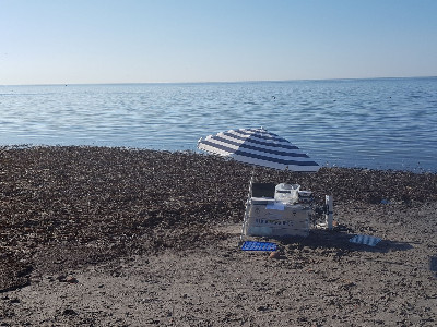 Measuring on the beach. The umbrella is to protect the equipment, not the researcher